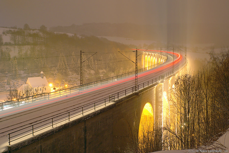 Beleuchteter Altenbekener Viadukt mit Zug